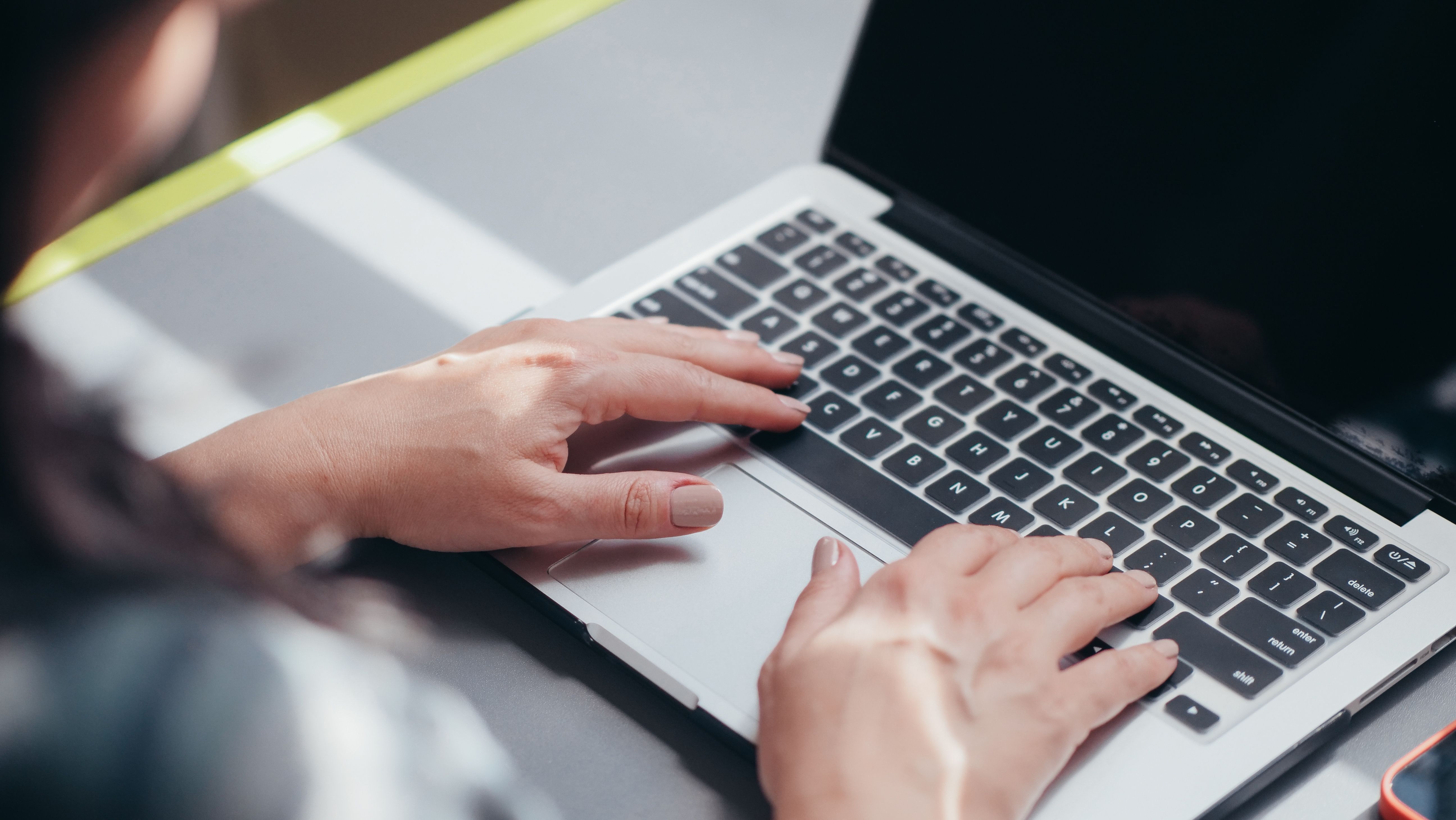 Mani su tastiera di laptop durante la configurazione di un prodotto complesso con software CPQ